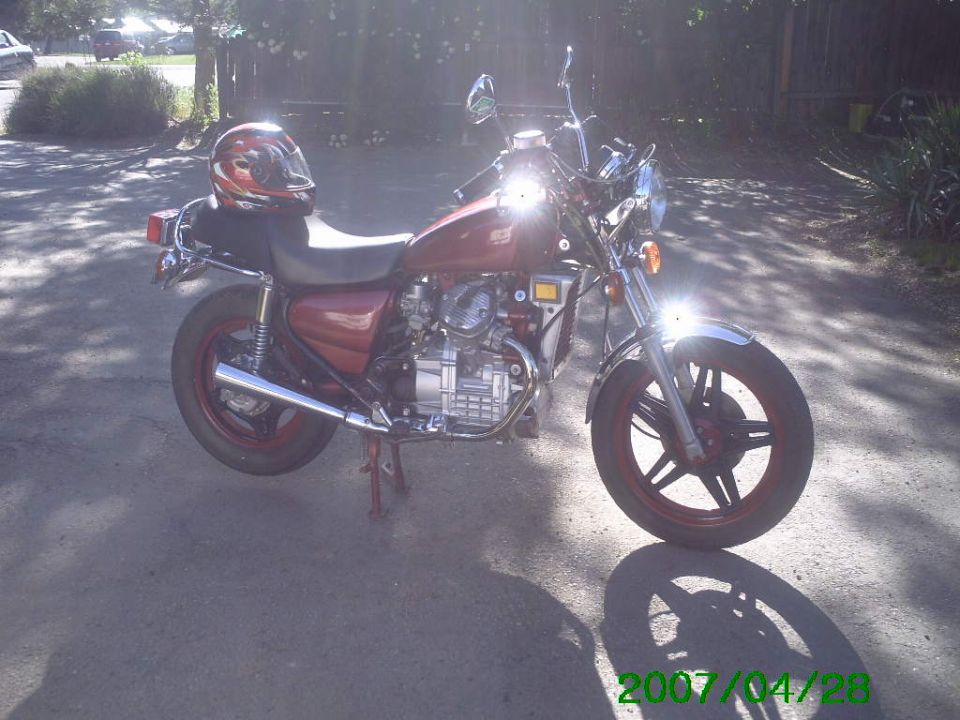 Red 1980 Honda CX500 motorcycle parked outdoors with a helmet on the seat