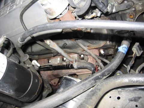 1990 Ford Bronco - Close-up view of an engine bay, showing various hoses, spark plugs, and electrical connectors.