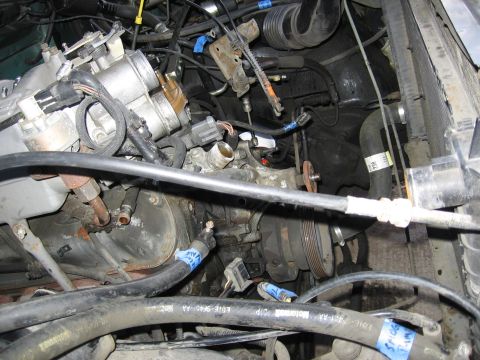 1990 Ford Bronco - Close-up view of an engine bay, showing hoses, belts, and mechanical parts.