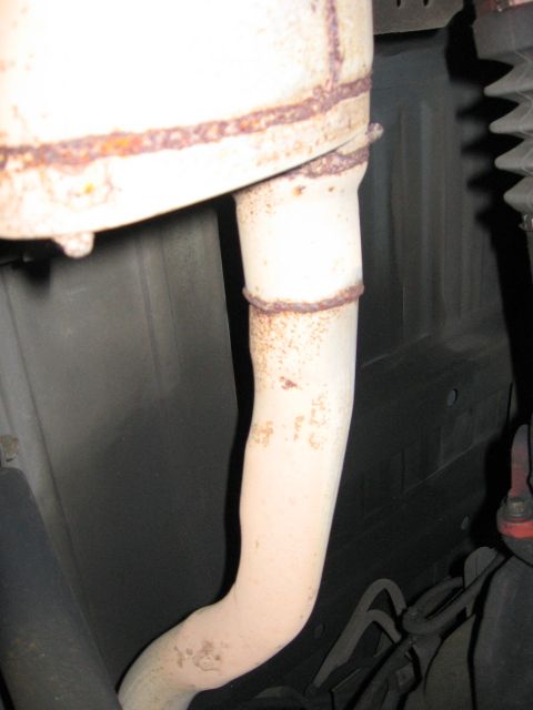 1990 Ford Bronco - Close-up view of a vehicle's exhaust pipe, showing signs of rust around the welded joints.