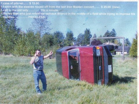 1989 Ford Bronco - A man stands next to his overturned SUV, holding a beer and a cell phone.