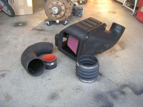 1996 Ford Bronco - Aftermarket cold air intake system components laid out on a concrete surface.