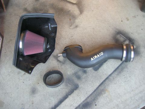 1996 Ford Bronco - AIRAID cold air intake system with red filter and black housing on concrete.