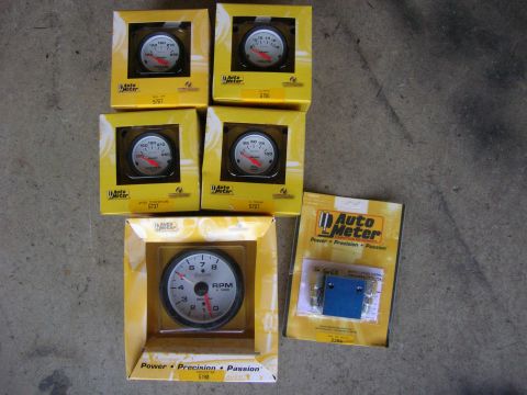 1996 Ford Bronco - Collection of Auto Meter gauges and parts, including a tachometer and other instruments.