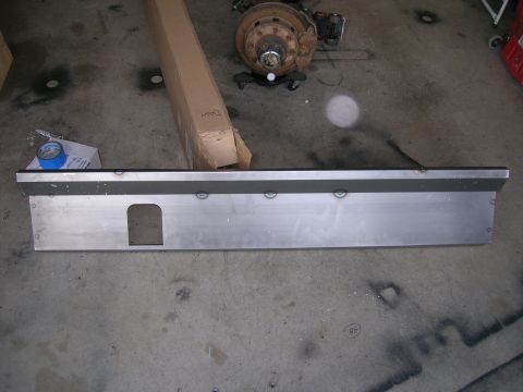 1996 Ford Bronco - A metal running board with a cut-out is shown on a garage floor, with a disassembled vehicle axle in the background.
