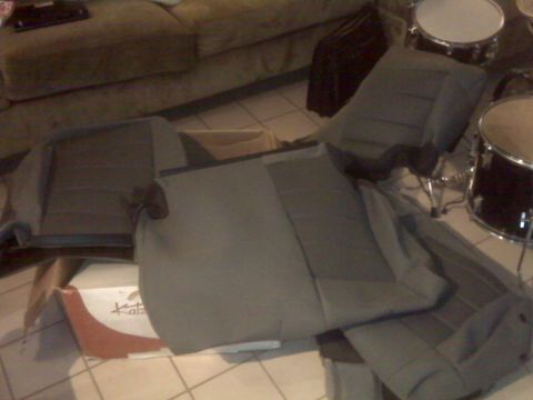2008 Jeep Wrangler - Gray seat covers are laid out on the floor, possibly for installation.
