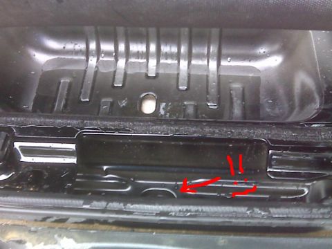 2008 Jeep Wrangler - Wet close-up of a black stamped-steel body panel and its weatherstrip channel, with a hand-drawn red arrow and exclamation marks added to t…