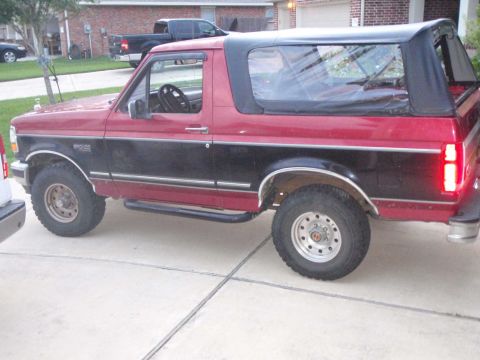 1994 Ford Bronco - This two-tone Ford Bronco features a removable soft top, offering an open-air driving experience.