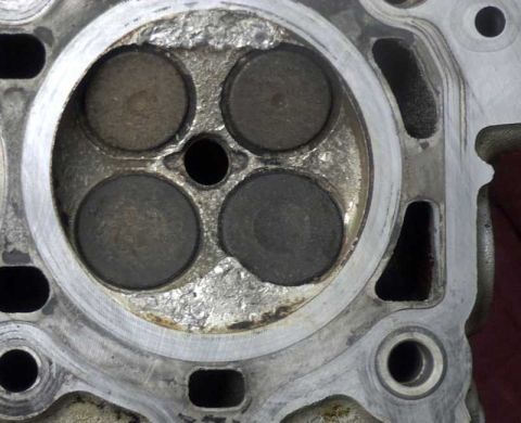 1997 Ford Taurus - Close-up of an engine cylinder head, showing wear and tear on the valves.