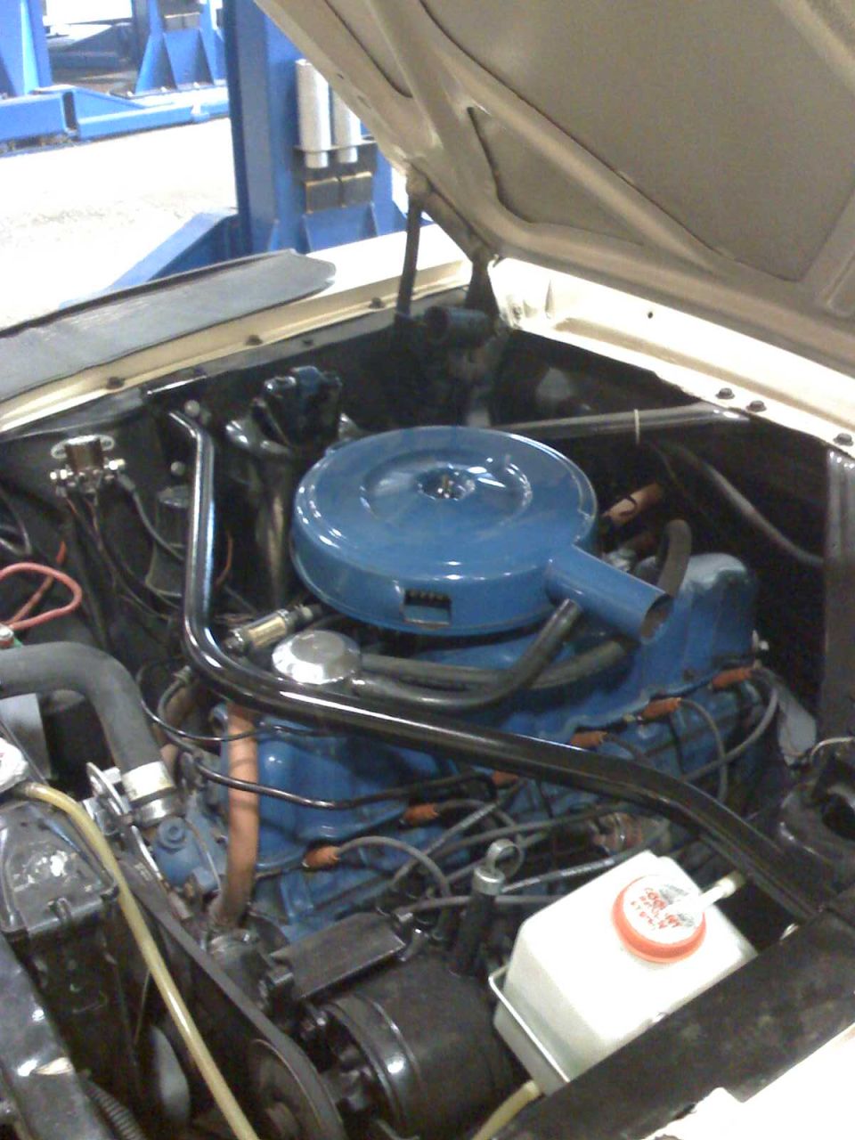 Engine bay showing blue air cleaner assembly and engine block
