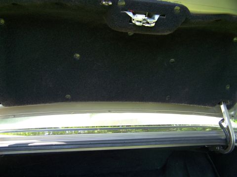 1987 Lincoln Mark VII - The interior of a car's trunk, showing the latch mechanism and carpeting.
