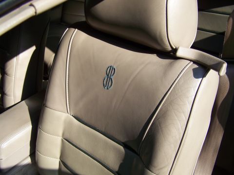 1987 Lincoln Mark VII - Tan leather interior seats with stitched detailing and an embroidered emblem.