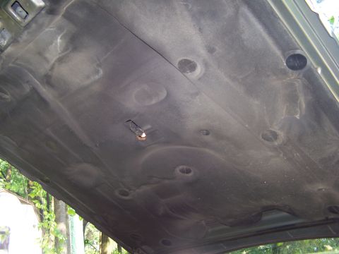 1987 Lincoln Mark VII - The underside of a car's hood insulation is visible, showing a textured surface with circular patterns.