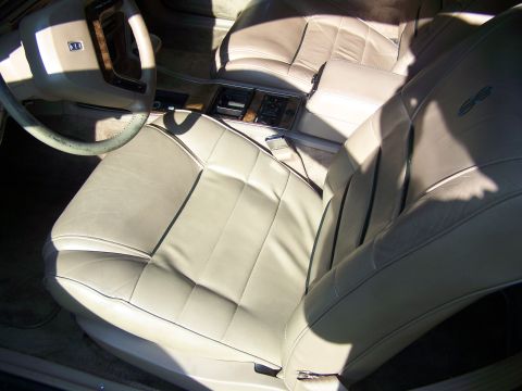 1987 Lincoln Mark VII - Interior shot of a car tan leather seats and wood accents on the dashboard and center console.