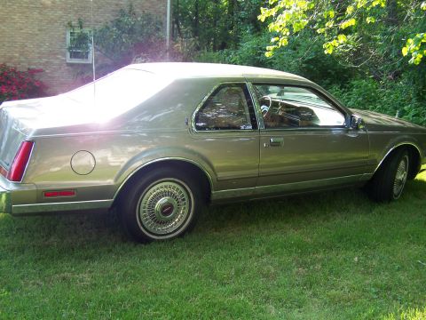 1987 Lincoln Mark VII - This 1987 Lincoln Mark VII is seen from the side, parked on a grassy lawn.