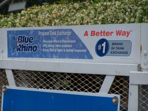 1990 Ford Bronco - Sign for Blue Rhino propane tank exchange service, advertising it as 'A Better Way' and '#1 Brand in Tank Exchange'.