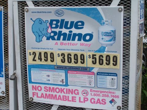 1990 Ford Bronco - Sign displays prices for propane tank exchange services from Blue Rhino, including important notices and emergency contact information.