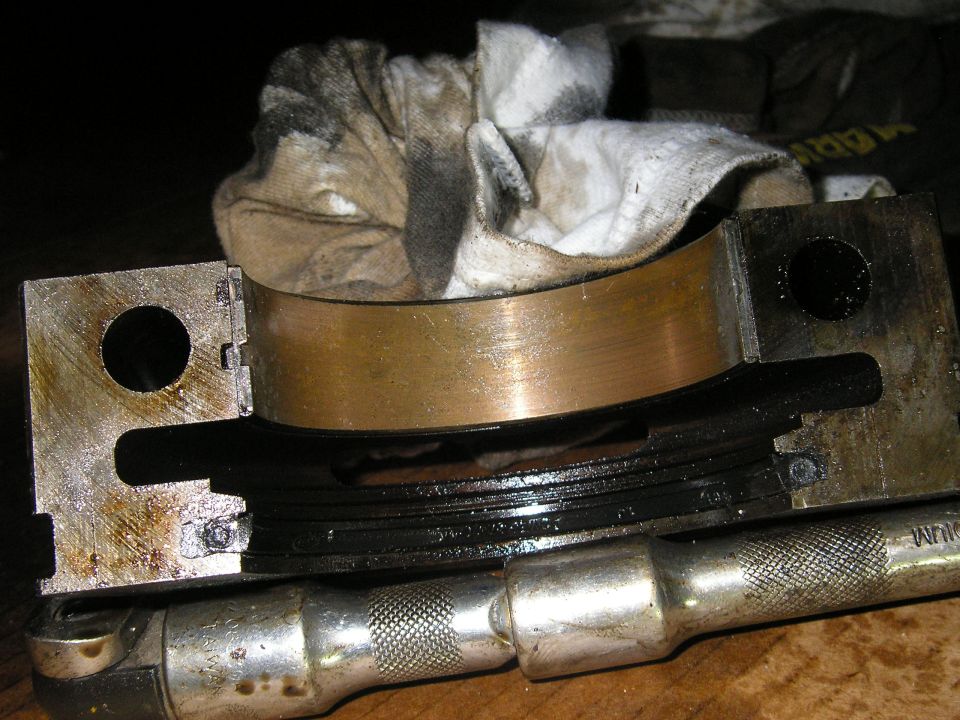 engine bearing assembly with dirty rag on top and socket wrench below