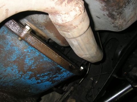 1979 Ford Bronco - Close-up view of a vehicle's undercarriage, showing a blue oil pan and exhaust pipe.