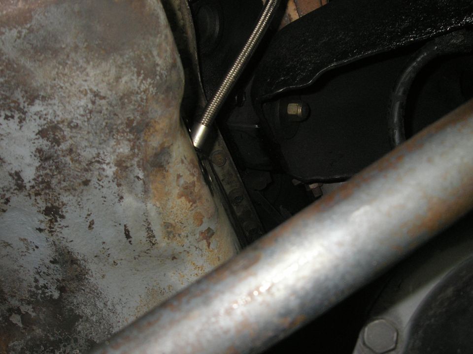 Underside view of vehicle showing oil pan, exhaust pipe, and suspension components