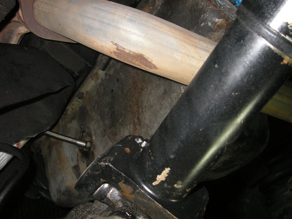 Underside of a vehicle showing exhaust pipe and part of the frame