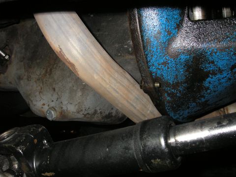 1979 Ford Bronco - Underside view of engine components, including the oil pan and exhaust pipe, with visible signs of age and use.