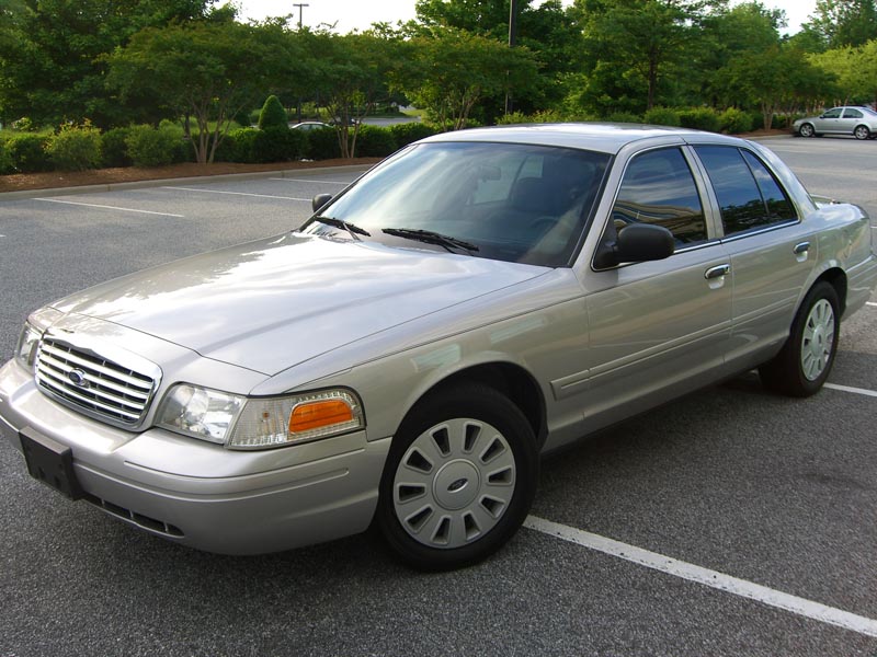 Silver 2006 Ford Crown Victoria sedan parked in a lot, front 3/4 view