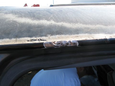 1986 Ford Bronco - Close-up view of a damaged roof edge, showing peeling material and rust.
