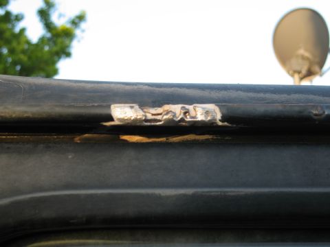 1986 Ford Bronco - Close-up of damaged black roof trim on a vehicle.