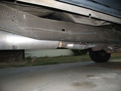 1986 Ford Bronco - Close-up view of the exhaust system and undercarriage of a vehicle.