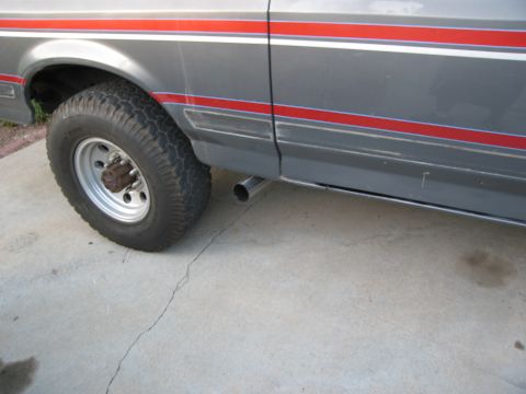 1986 Ford Bronco - Side view of a 1986 Ford Bronco, focusing on the exhaust pipe and body trim.