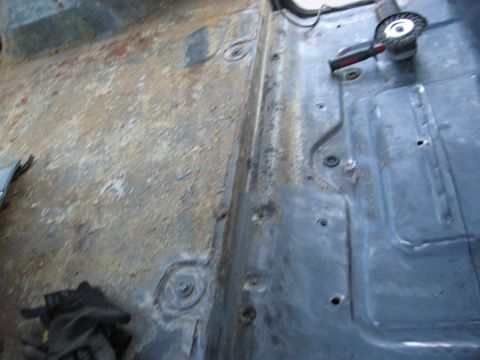 1986 Ford Bronco - Grinding away rust from a vehicle's floor panel, preparing for restoration.