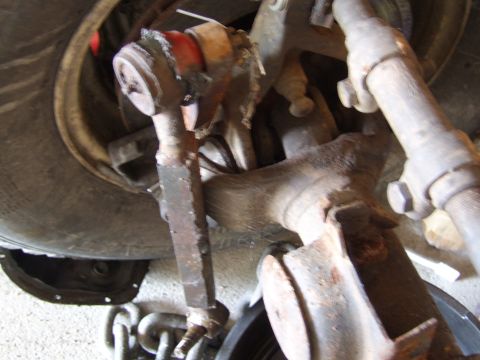 2002 Jeep TJ - Close-up of a rusty Jeep TJ Dana 44 axle component, with a tire in the background.