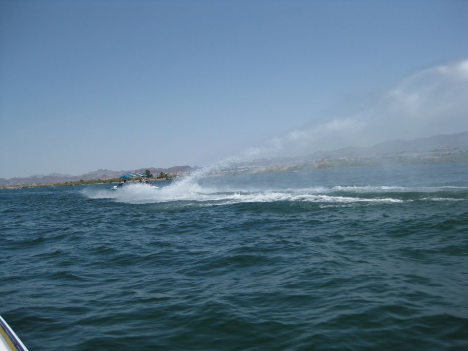 Personal watercraft throwing a tall rooster tail of spray on open water