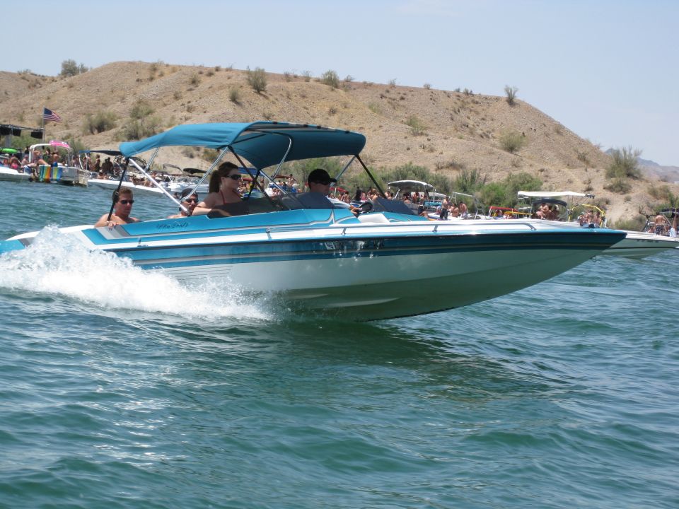 Blue and white boat with canopy on the water, people onboard