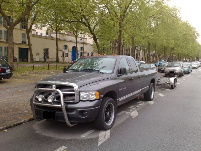 Gray Dodge Ram pickup truck towing a trailer, front bull bar with lights