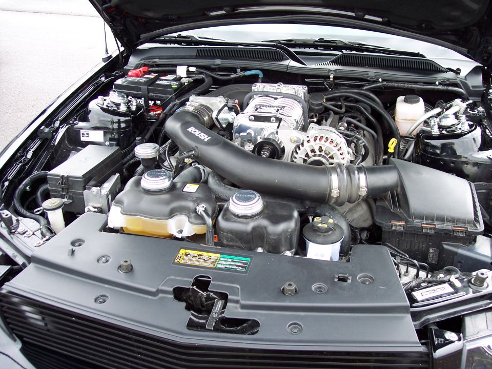 Engine bay with Roush supercharger, air intake, and battery
