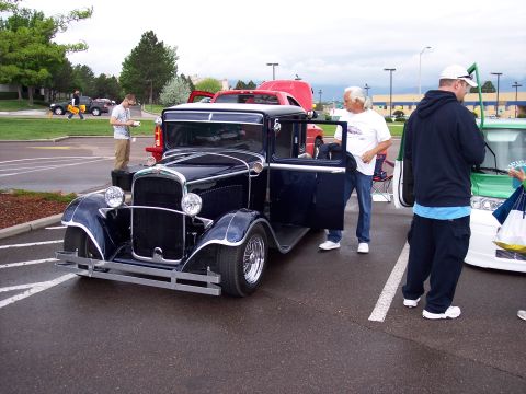 1972 Ford Ranchero - A dark blue vintage coupe is parked with its doors open, while people gather around it.