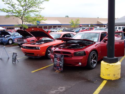 1972 Ford Ranchero - Two modern Dodge muscle cars are displayed with hoods open at an outdoor event, with a Sam's Club store in the background.
