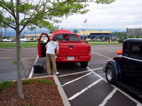 1972 Ford Ranchero - A red pickup truck is parked in a handicapped spot while a person loads items into its open door. Another vintage car is parked nearby.
