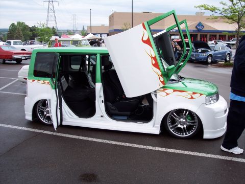 1972 Ford Ranchero - A customized van with its doors open is parked in a lot near a Sam's Club.