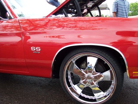 1972 Ford Ranchero - A close-up view of a red muscle car's fender, its SS 396 badging and a custom chrome wheel.