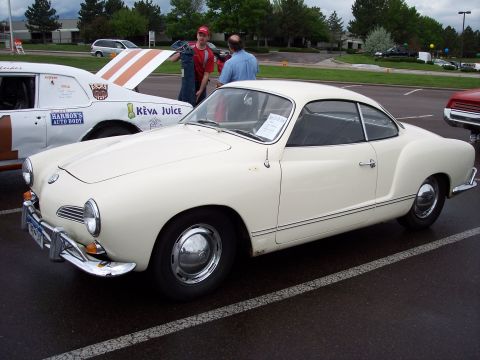 1972 Ford Ranchero - A classic Volkswagen Karmann Ghia is parked at an outdoor event, with another car's hood open in the background.