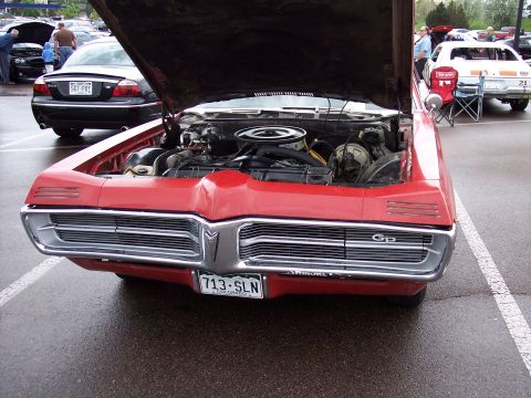 1972 Ford Ranchero - A red 1970 Pontiac Grand Prix is displayed with its hood open, revealing the engine compartment.