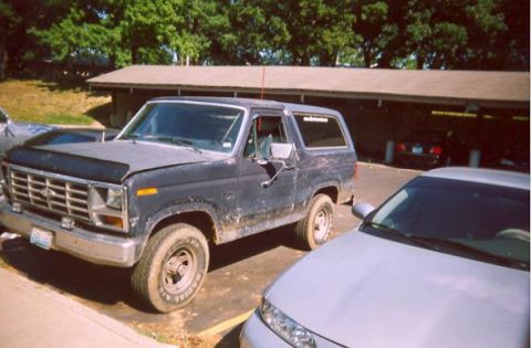 1982 Ford Bronco - This 1980s Ford Bronco is parked outdoors next to another vehicle.