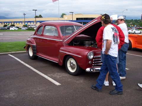 1972 Ford Ranchero - Classic red coupe with hood open, showing the engine to onlookers.