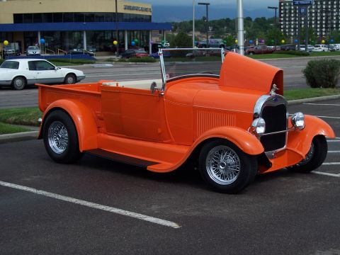 1972 Ford Ranchero - This custom pickup truck features a bright orange paint job and wire-spoke wheels.
