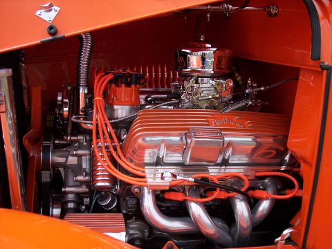 1972 Ford Ranchero - The engine bay of a custom hot rod features a polished Edelbrock V8 engine with bright orange accents and wiring.