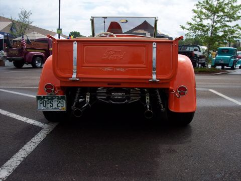 1972 Ford Ranchero - Rear view of an orange Ford pickup truck with a custom exhaust and a "POPS 29" license plate.