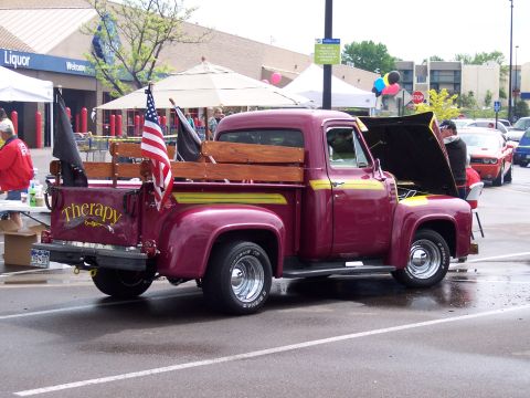 1972 Ford Ranchero - A classic Ford pickup truck is parked in a lot, with its hood open and an American flag displayed in the bed.